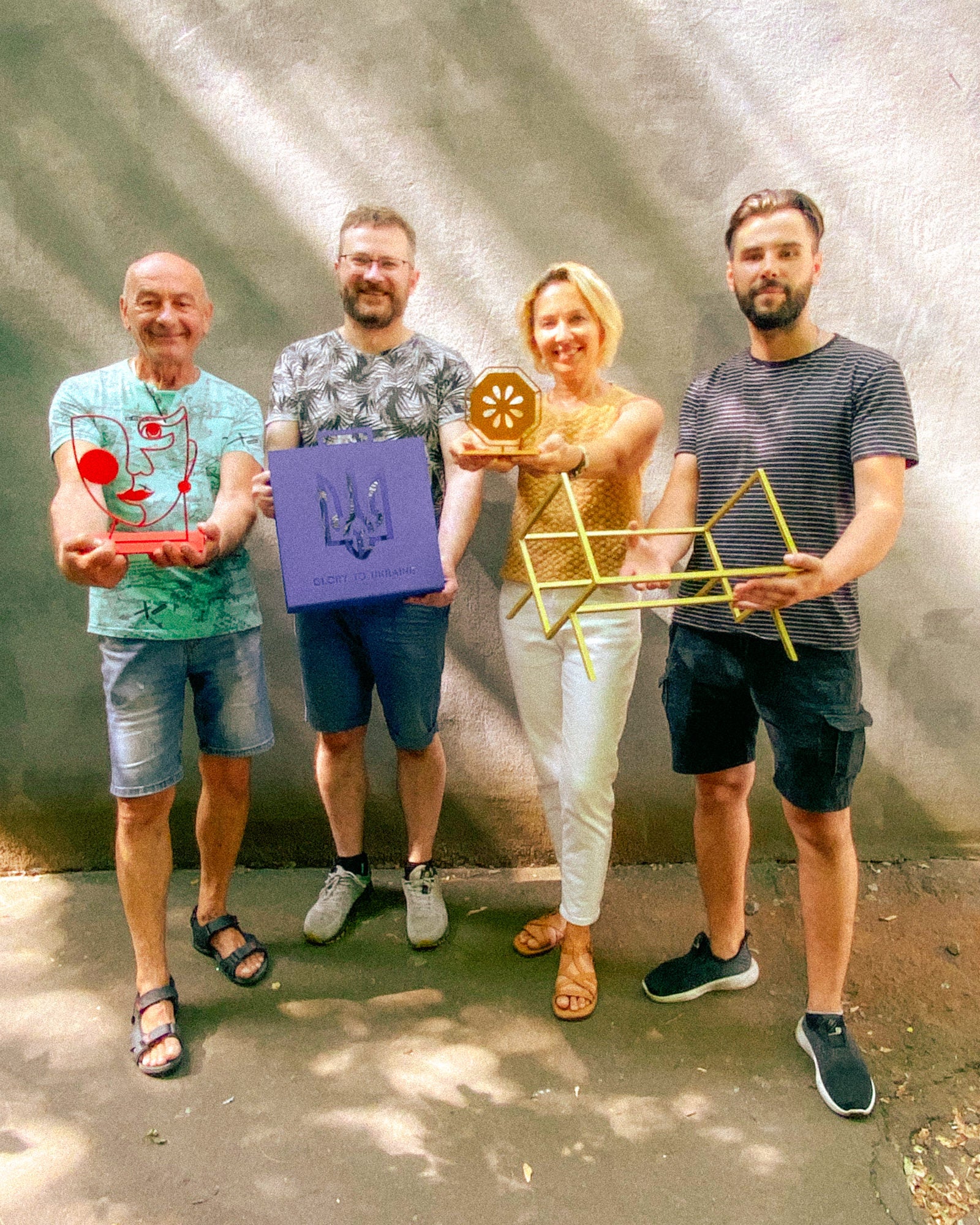Atelier Article workshop team in Cherkasy, Ukraine, holding handmade metal objects