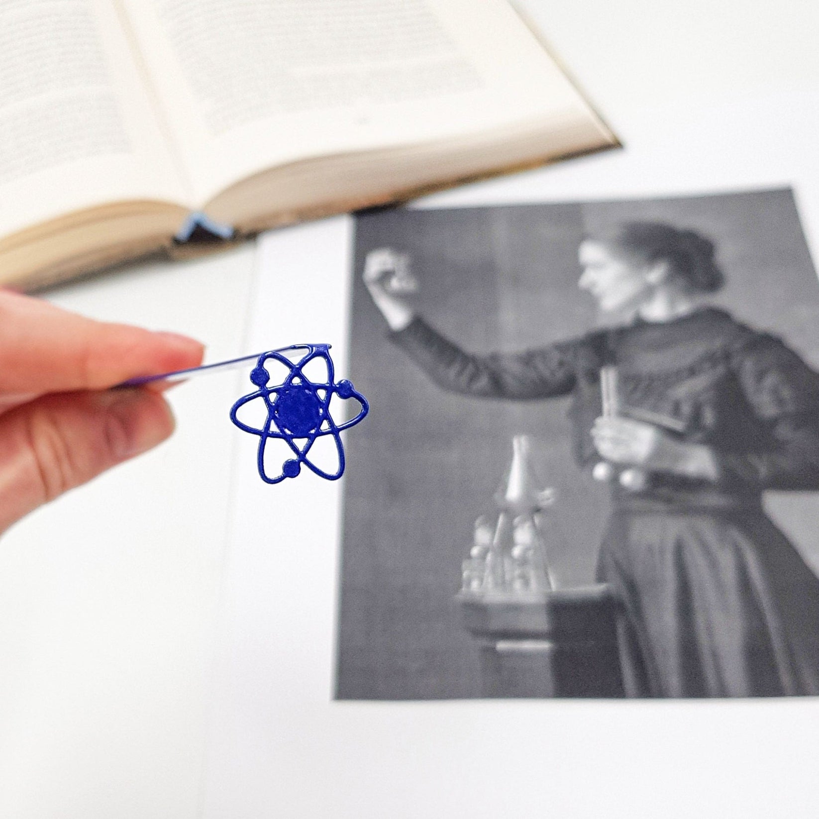Atom metal bookmark on an illustrated page