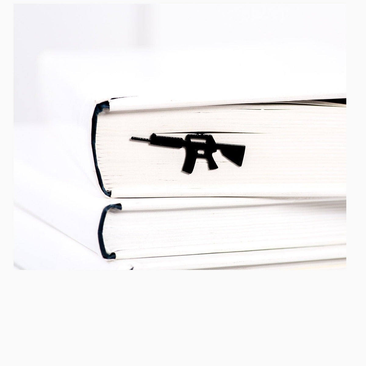 Automatic Rifle metal bookmark in a closed book, only its top showing above the pages