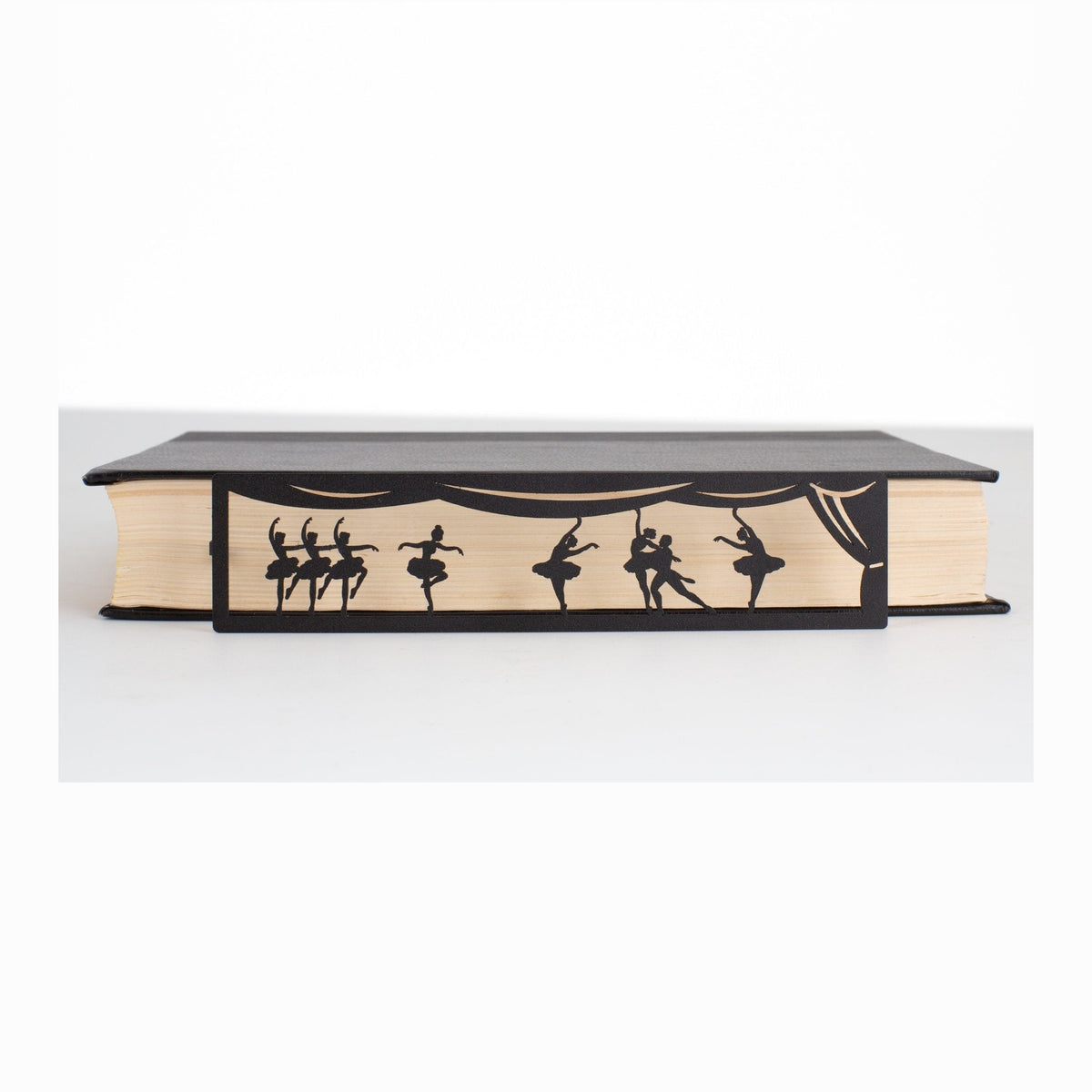 Ballet metal bookmark in a closed book, only its top showing above the pages