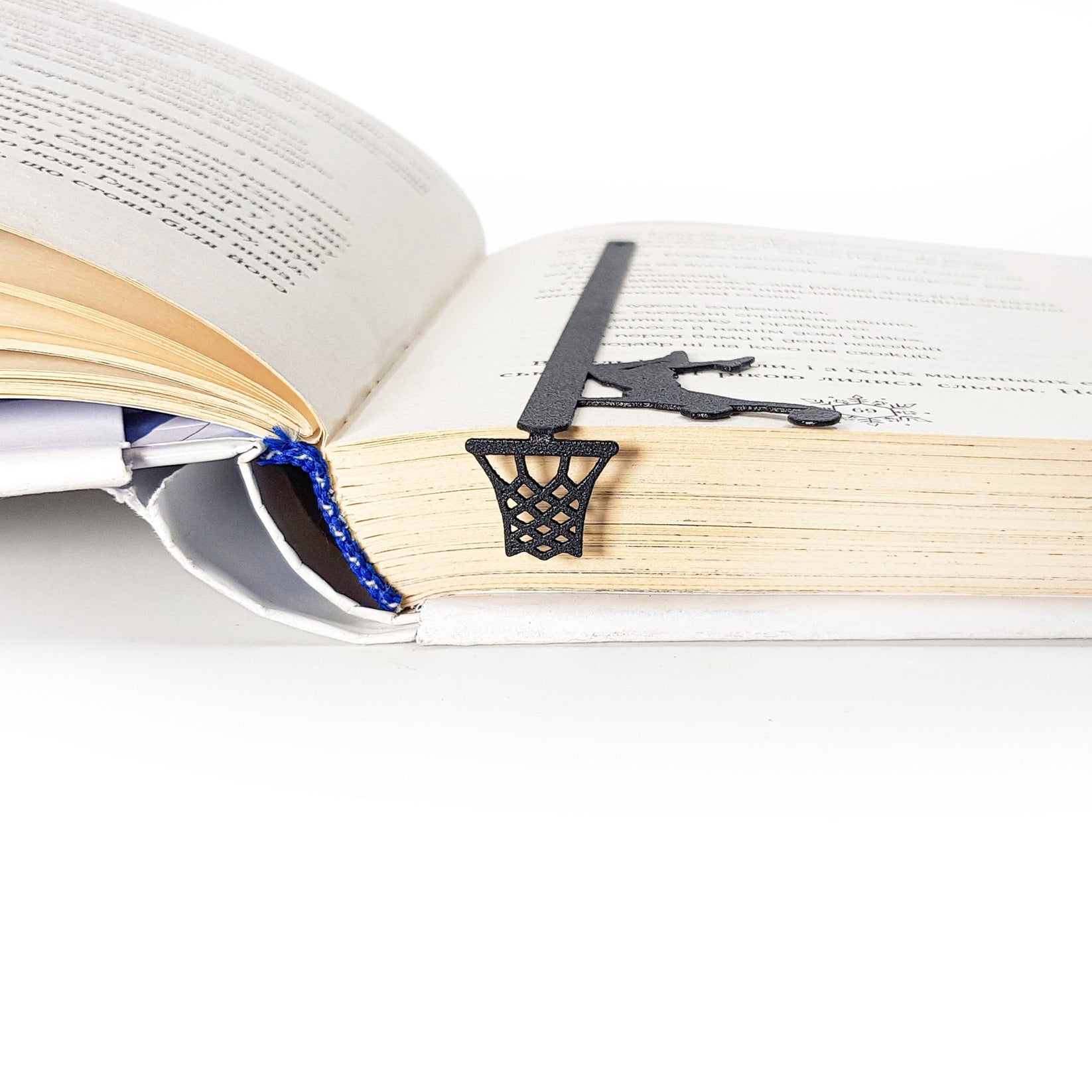 Basketball metal bookmark resting on the pages of an open book