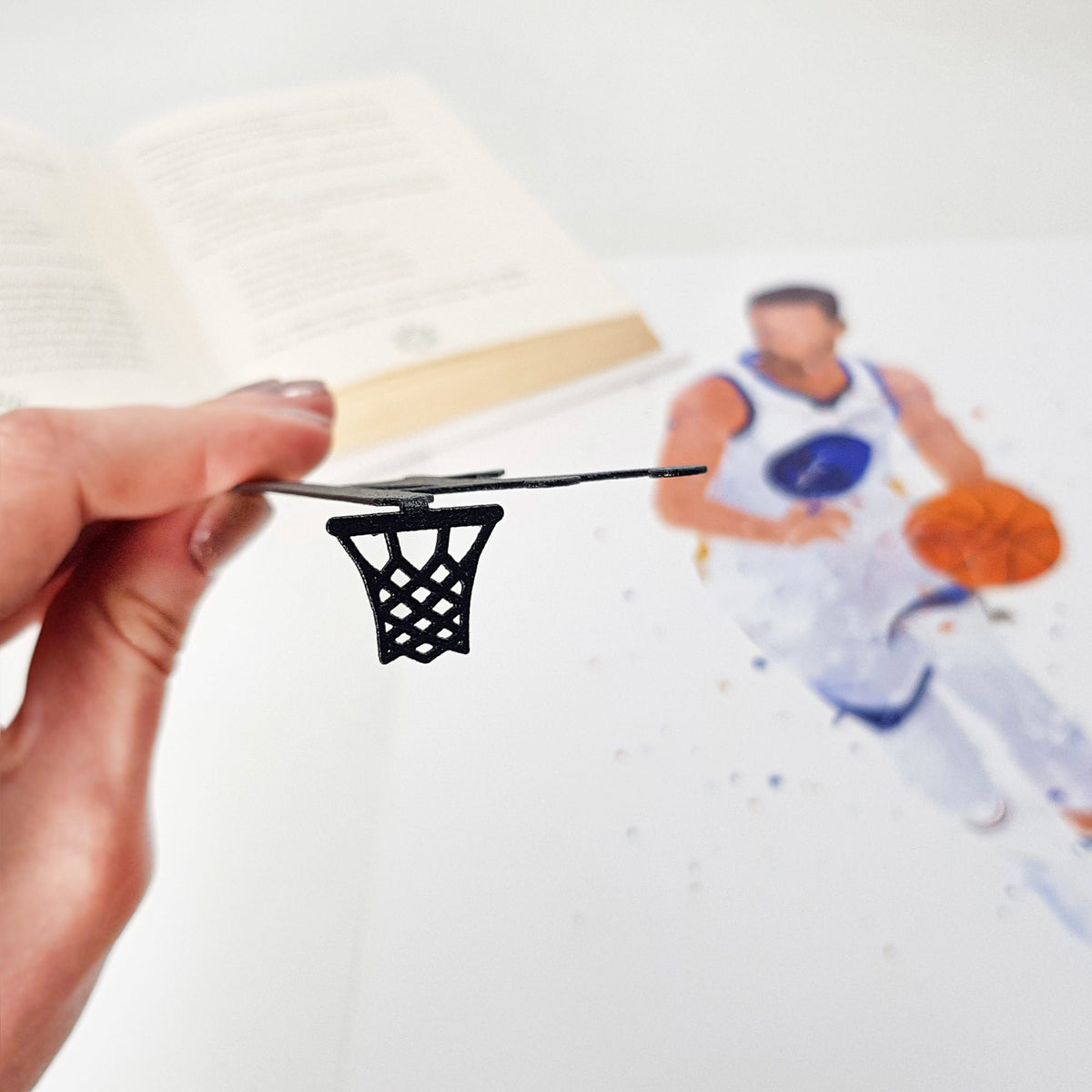 Basketball metal bookmark marking a page in an illustrated book, view 4