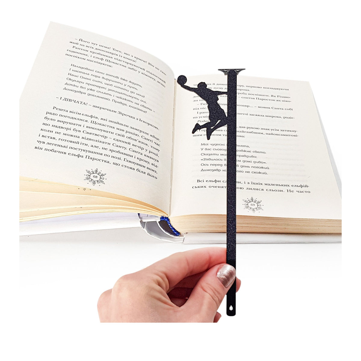 Basketball metal bookmark held in a hand above an open book