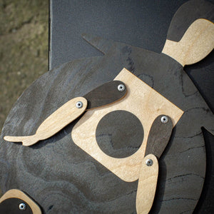 Extreme close-up of the Beetle puppet's jointed arms, metal rivets and stained plywood texture