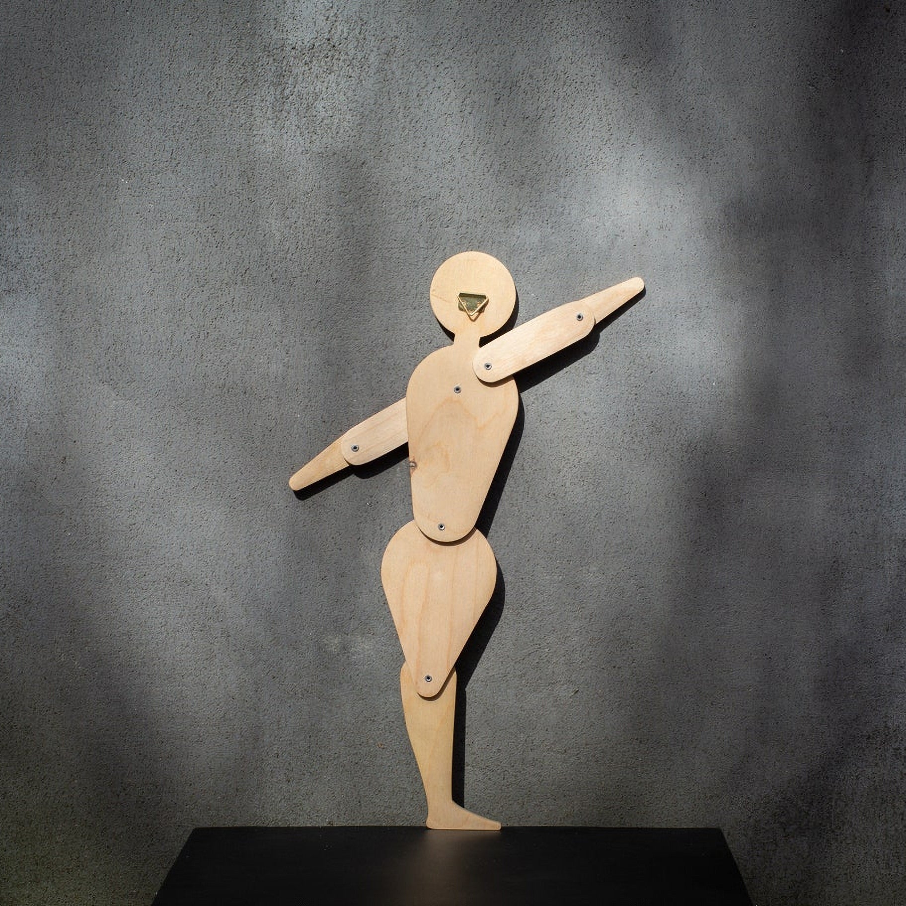 Back of Bauhaus circle dancer puppet in natural plywood showing brass wall hook and jointed construction