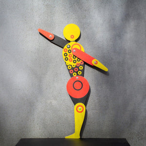Bauhaus circle dancer puppet on grey wall with arms extended, casting dramatic shadow