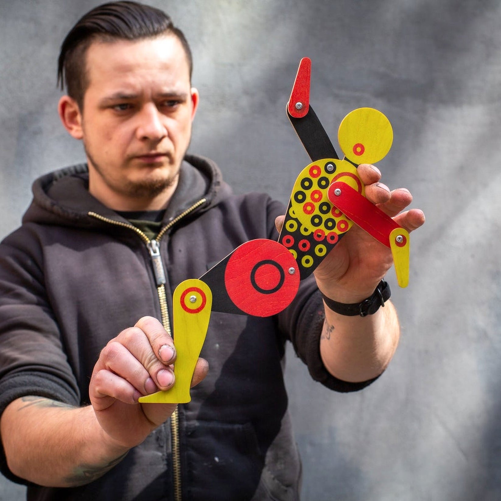Maker posing Bauhaus circle dancer puppet with both hands showing movable jointed limbs