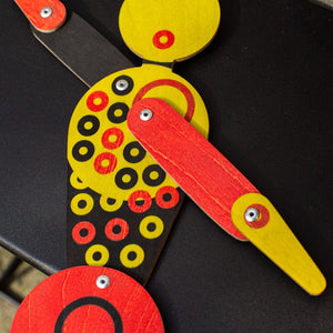 Close-up of Bauhaus circle dancer puppet showing printed geometric circles and metal joints