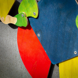 Detail of Bauhaus harlequin puppet — painted plywood surface showing wood grain beneath bold color