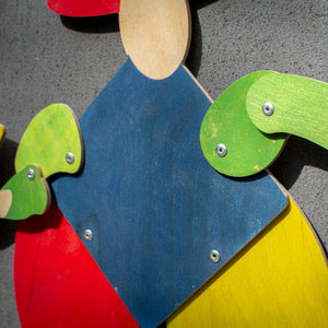 Close-up of Bauhaus harlequin puppet showing metal rivets, plywood layers and painted wood grain