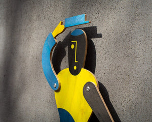 Close-up of puppet face with yellow geometric features on black plywood