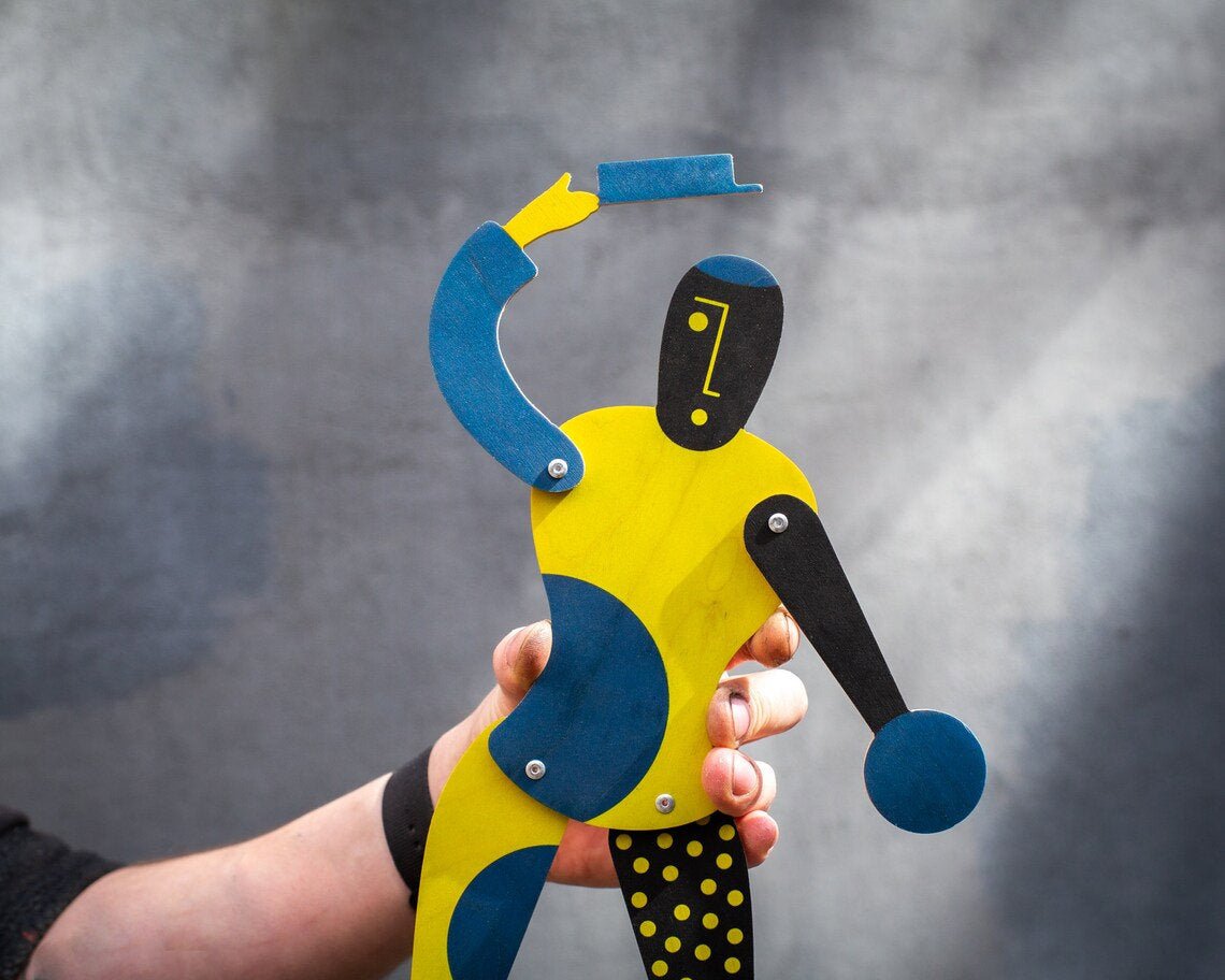 Hand holding Bauhaus puppet showing scale and movable limbs