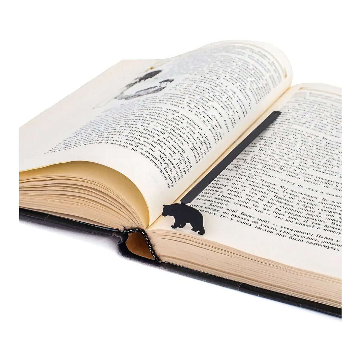 Bear metal bookmark resting on the pages of an open book