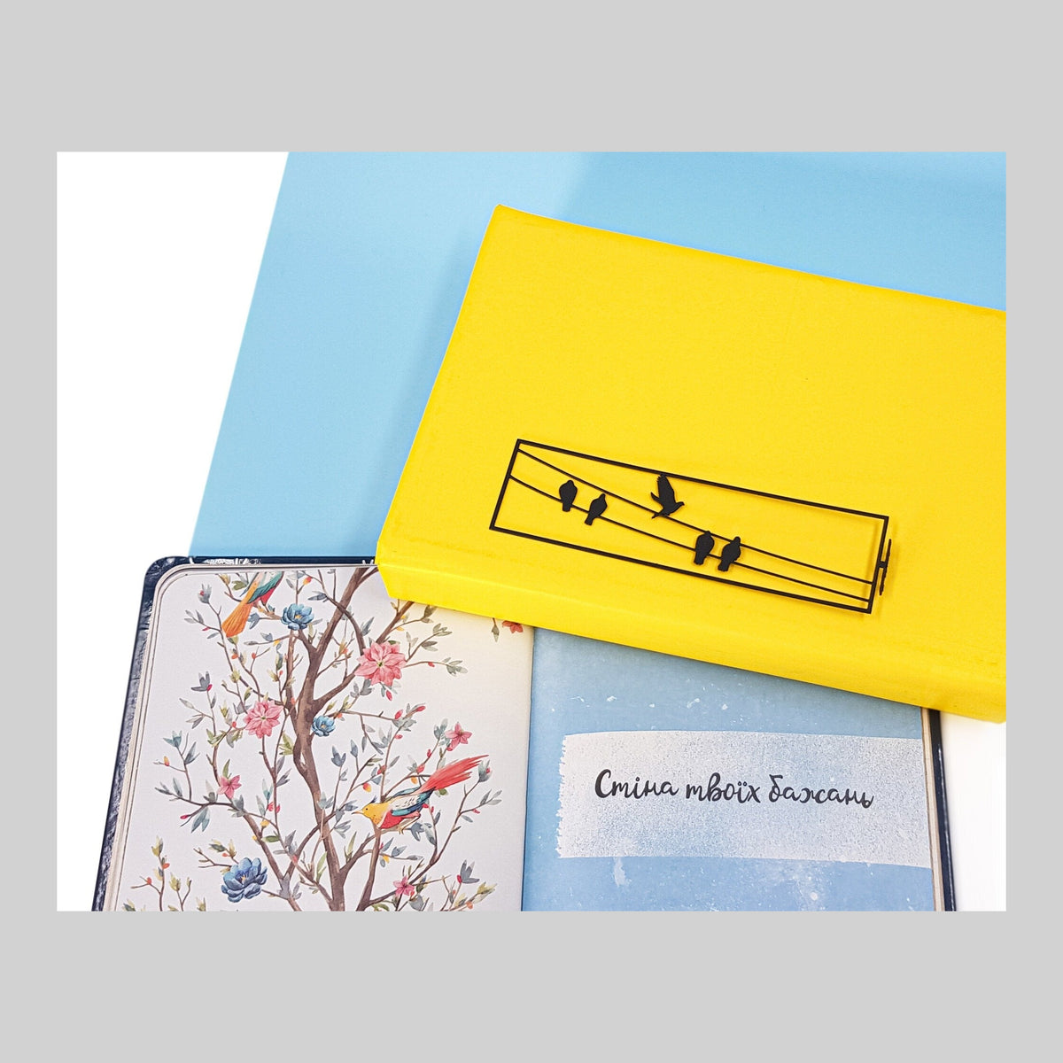 Birds on the Wire metal bookmark on a coloured background