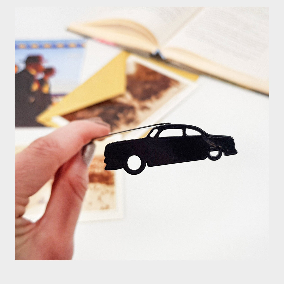 Black Car Phantom metal bookmark marking a page in an illustrated book