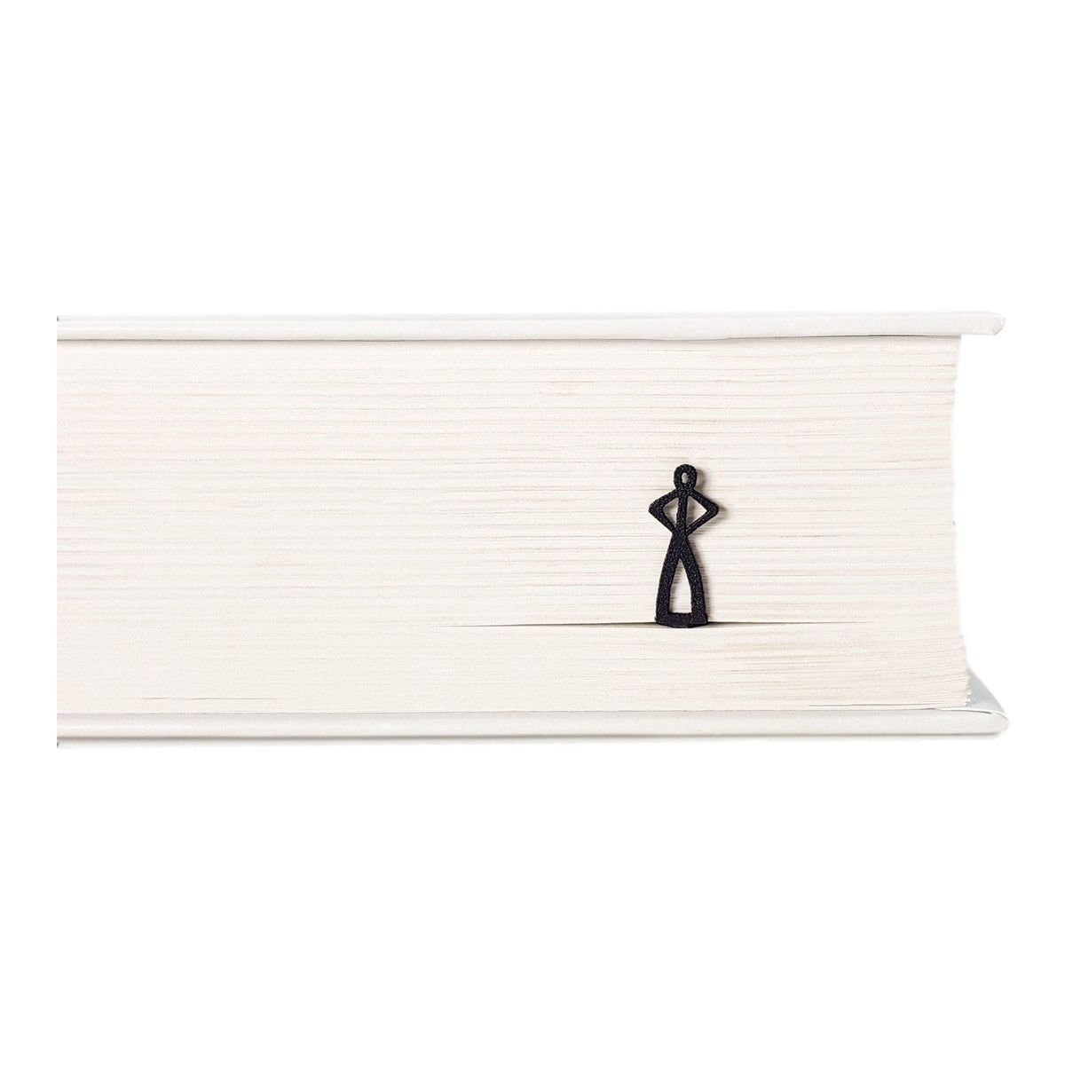 Black Stick Man metal bookmark in a closed book, only its top showing above the pages