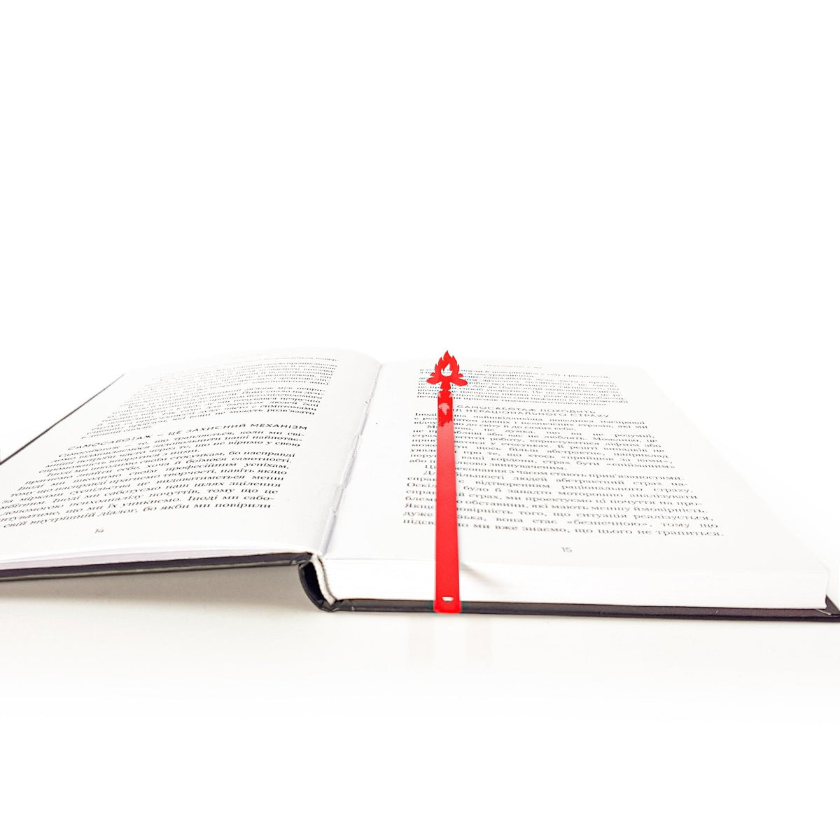 Bonfire metal bookmark in red set into the gutter of an open book