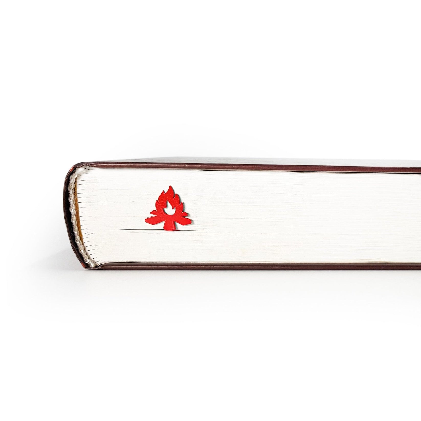 Bonfire metal bookmark in red seen from the edge of a closed book
