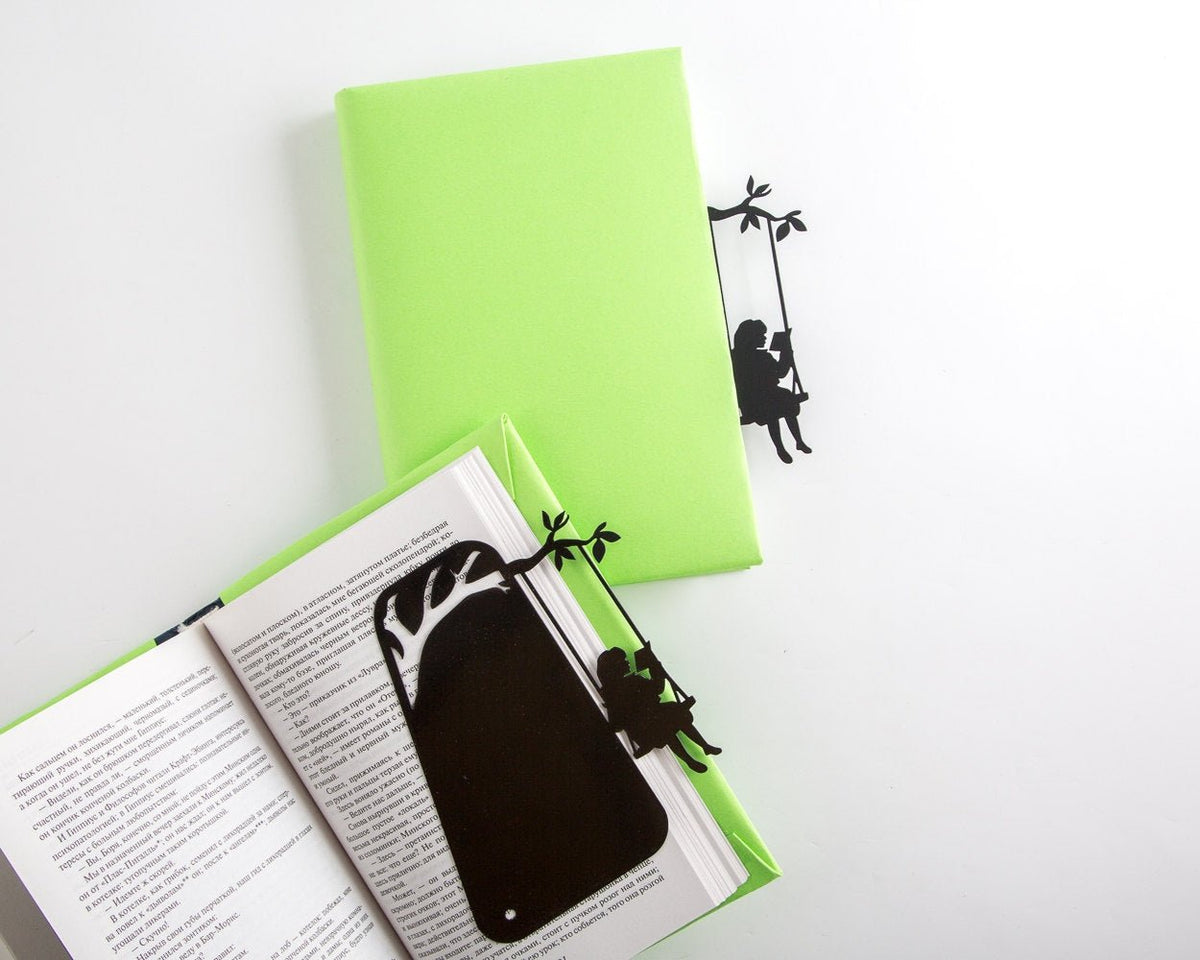 Book Divider Girl on a Swing metal bookmark seen from the edge of a closed book