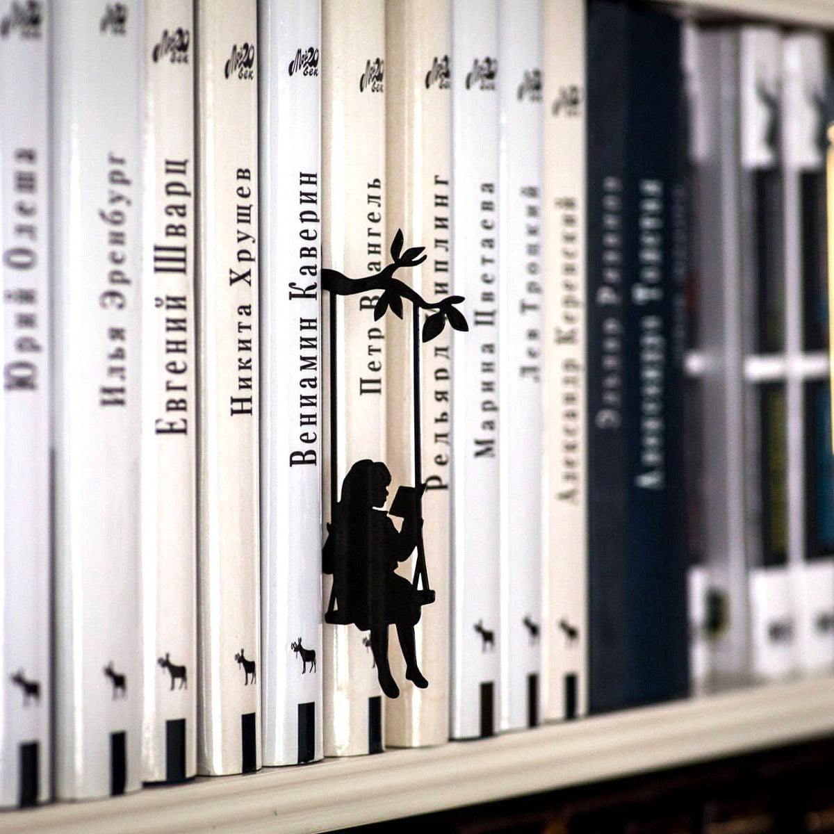 Book Divider Girl on a Swing metal bookmark shown with a stack of books