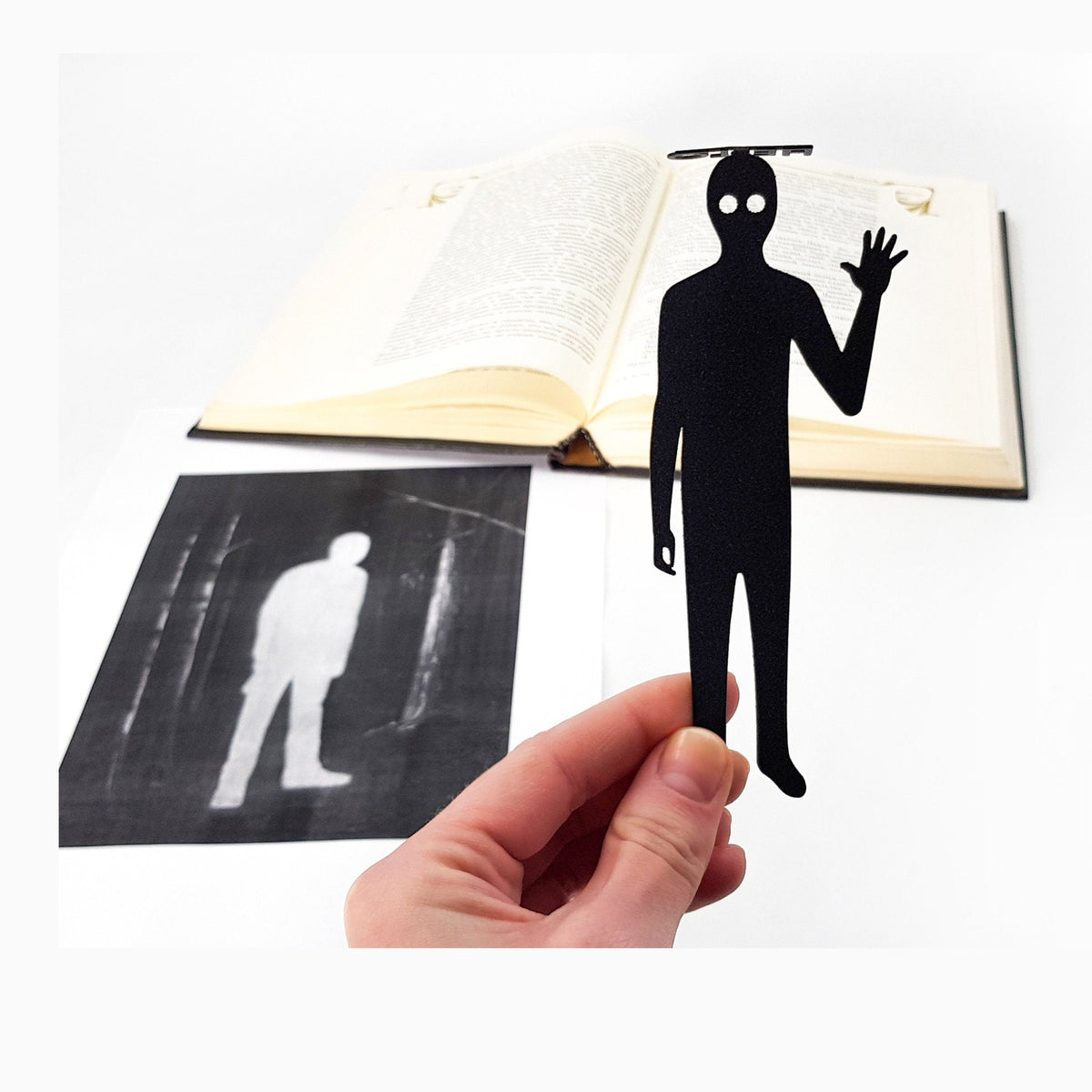 Book Ghost metal bookmark resting on the pages of an open book