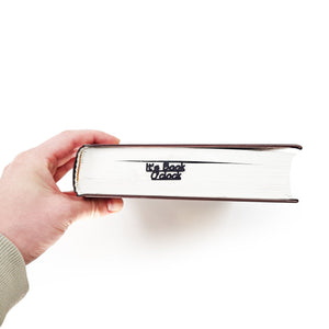 Hand holding a book with 'It's Book O'Clock' text on a white background