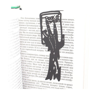 Book of Zombies metal bookmark resting on the pages of an open book