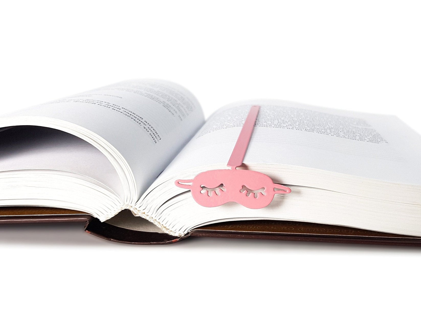 Sleep Mask metal bookmark in red marking a page in an open book