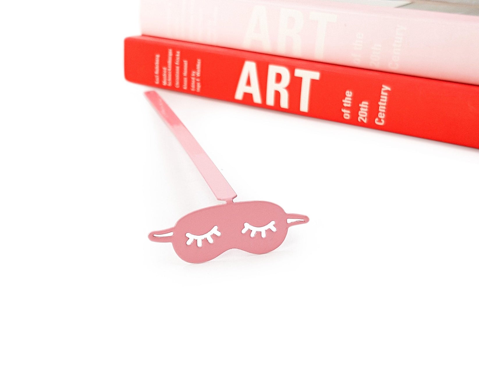 Sleep Mask metal bookmark in red seen from the edge of a closed book