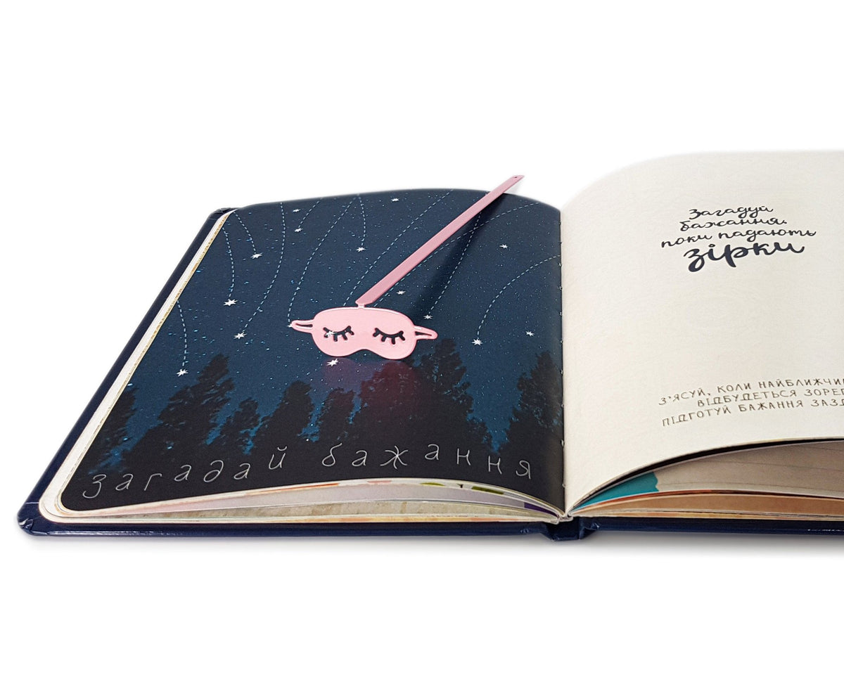 Sleep Mask metal bookmark in red set into the gutter of an open book