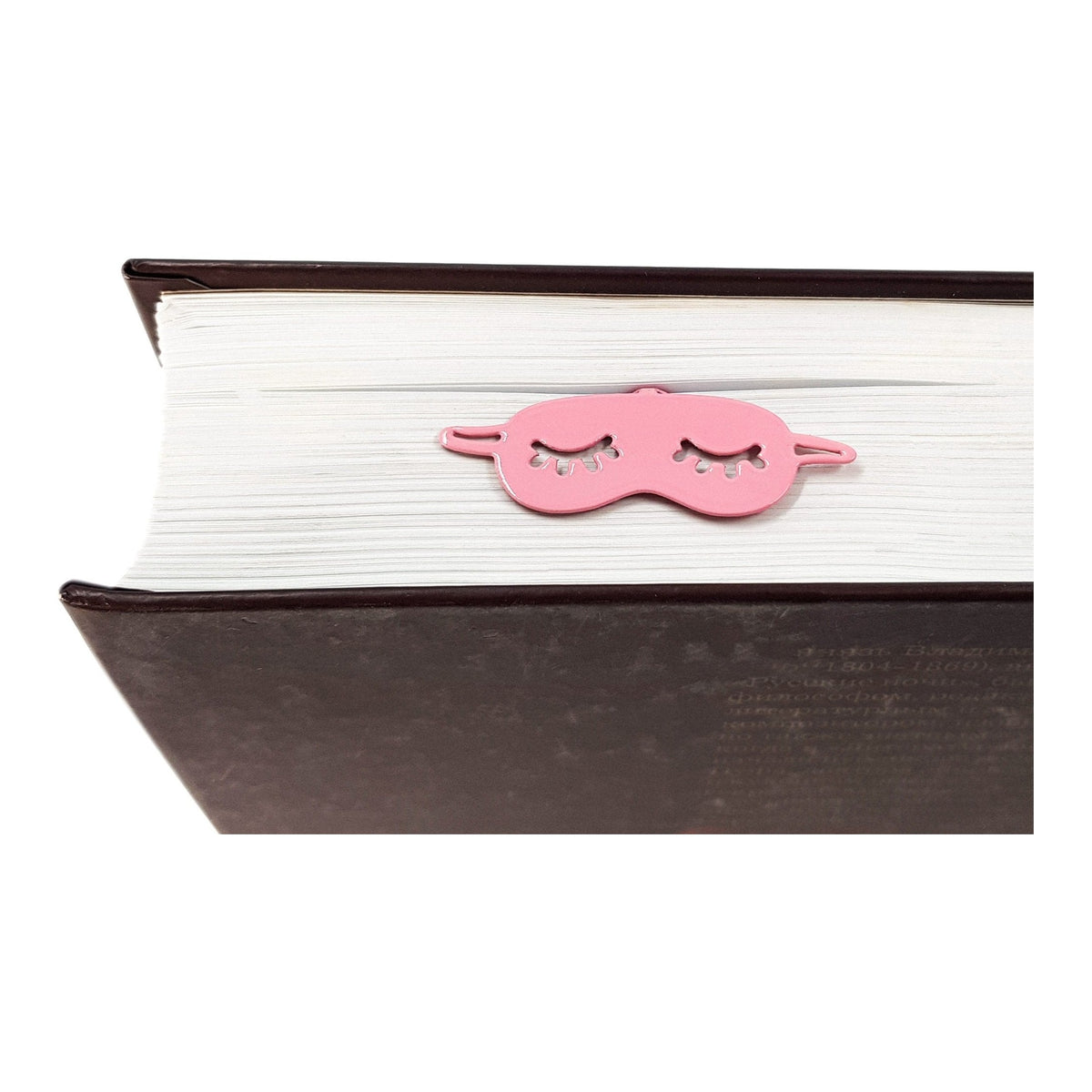 Sleep Mask metal bookmark in red resting on the pages of an open book