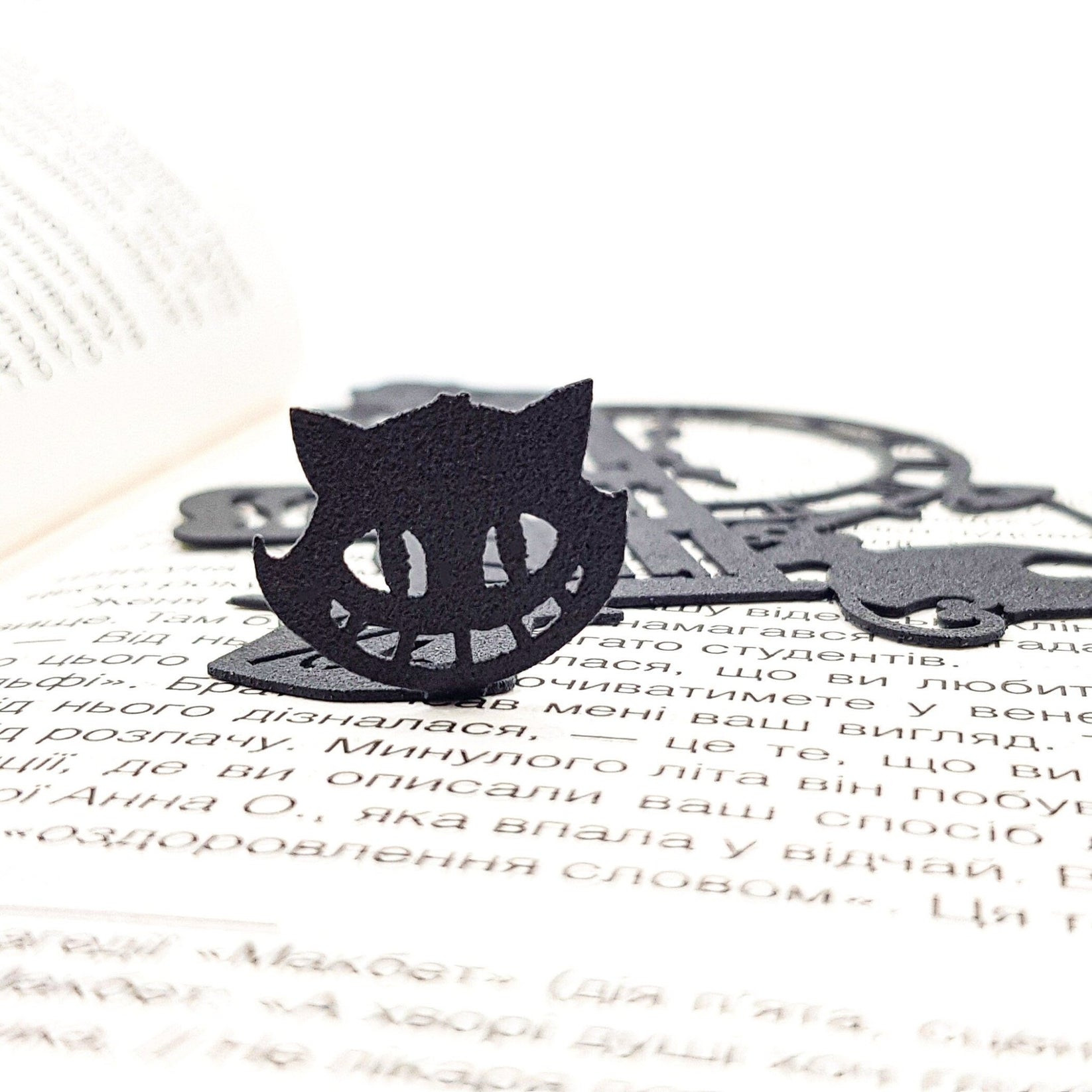 Alice in Wonderland's The Tea Party metal bookmark marking a page in an illustrated book