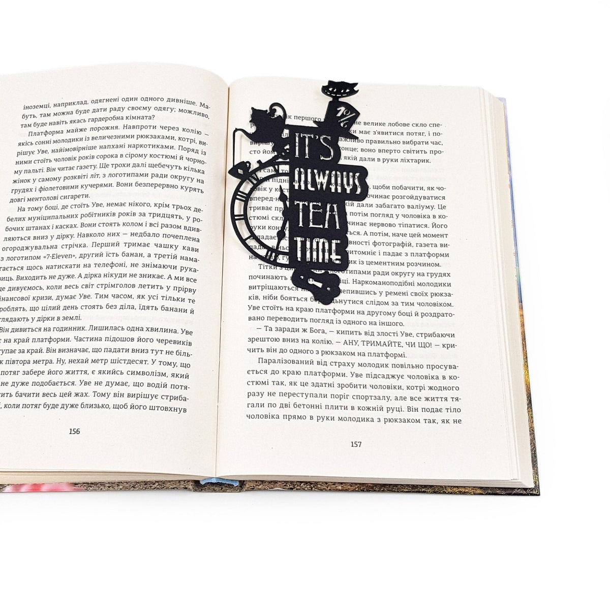 Alice in Wonderland's The Tea Party metal bookmark marking a page in an open book