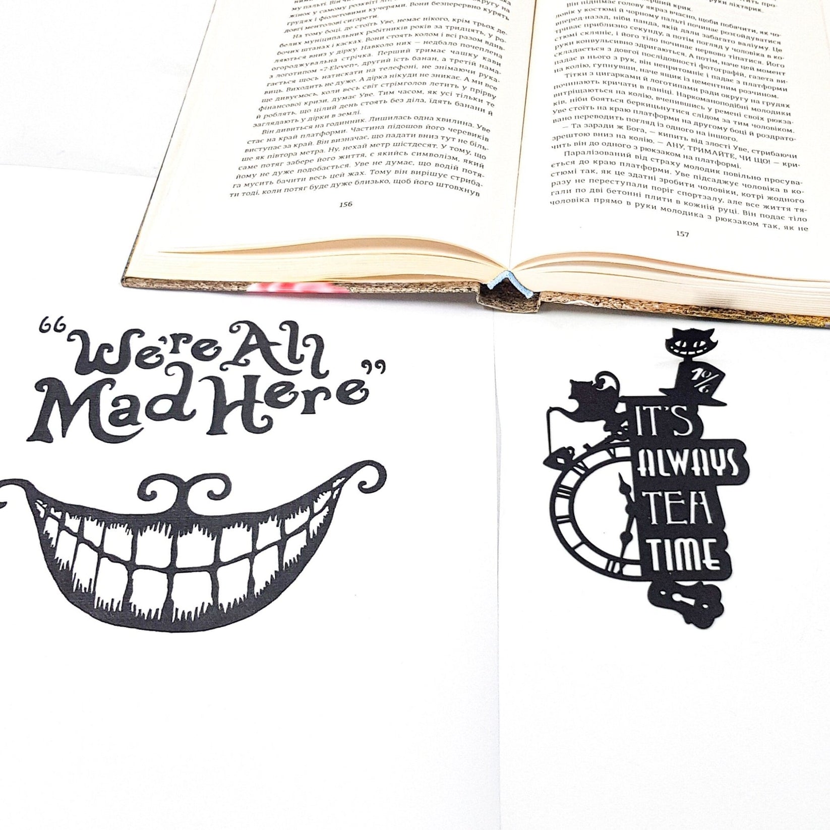 Alice in Wonderland's The Tea Party metal bookmark on an illustrated page