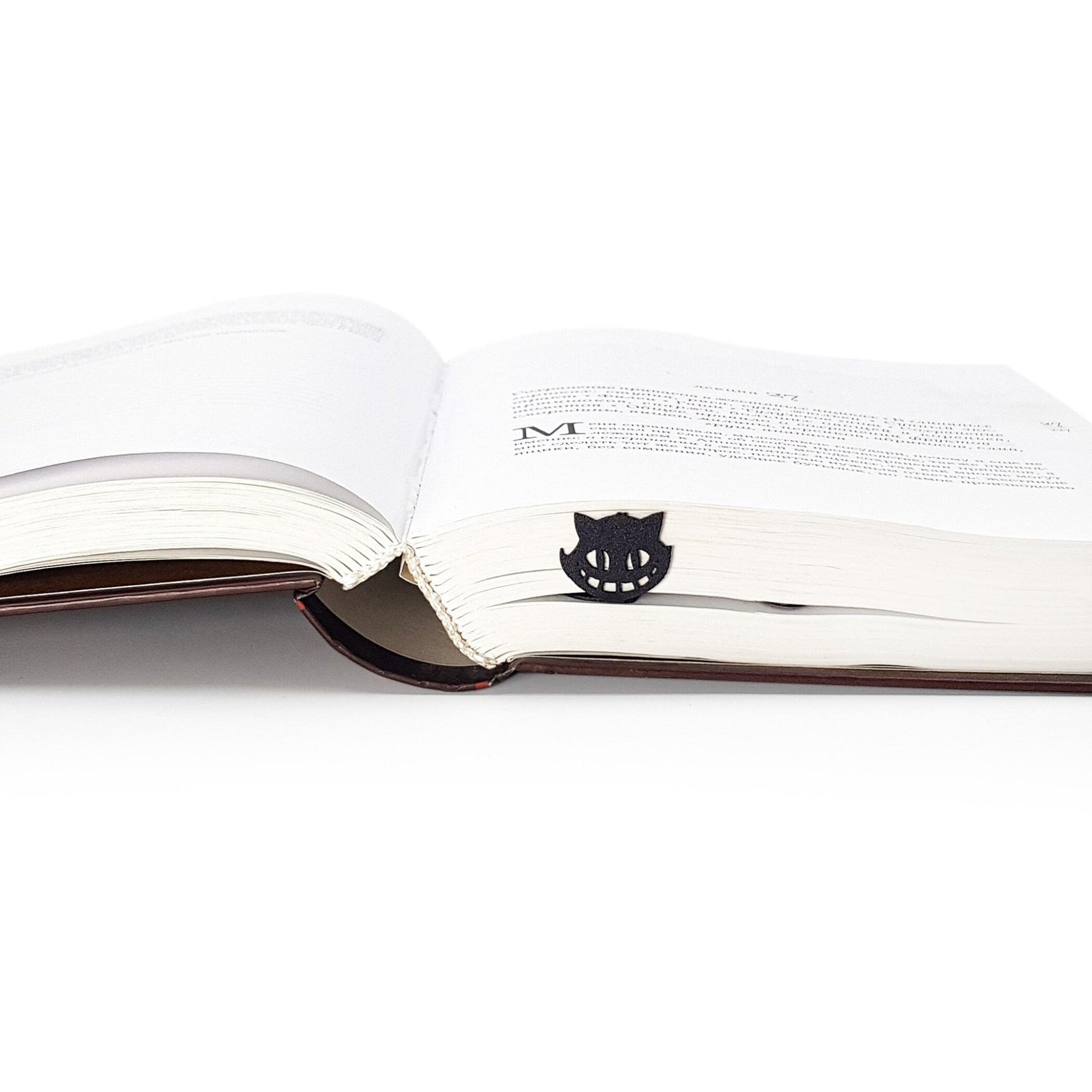 Alice in Wonderland's The Tea Party metal bookmark resting on the pages of an open book
