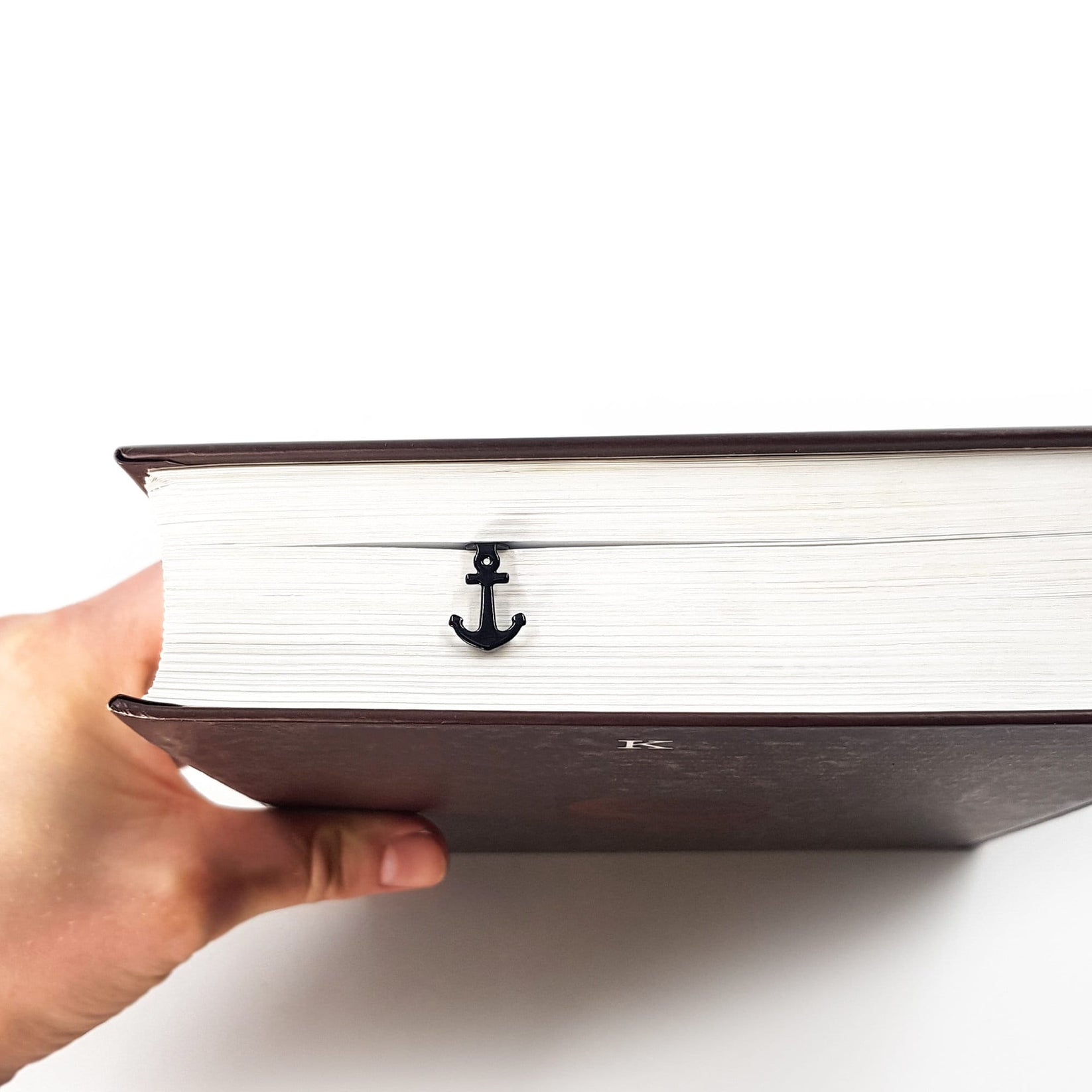 Anchor metal bookmark seen from the edge of a closed book