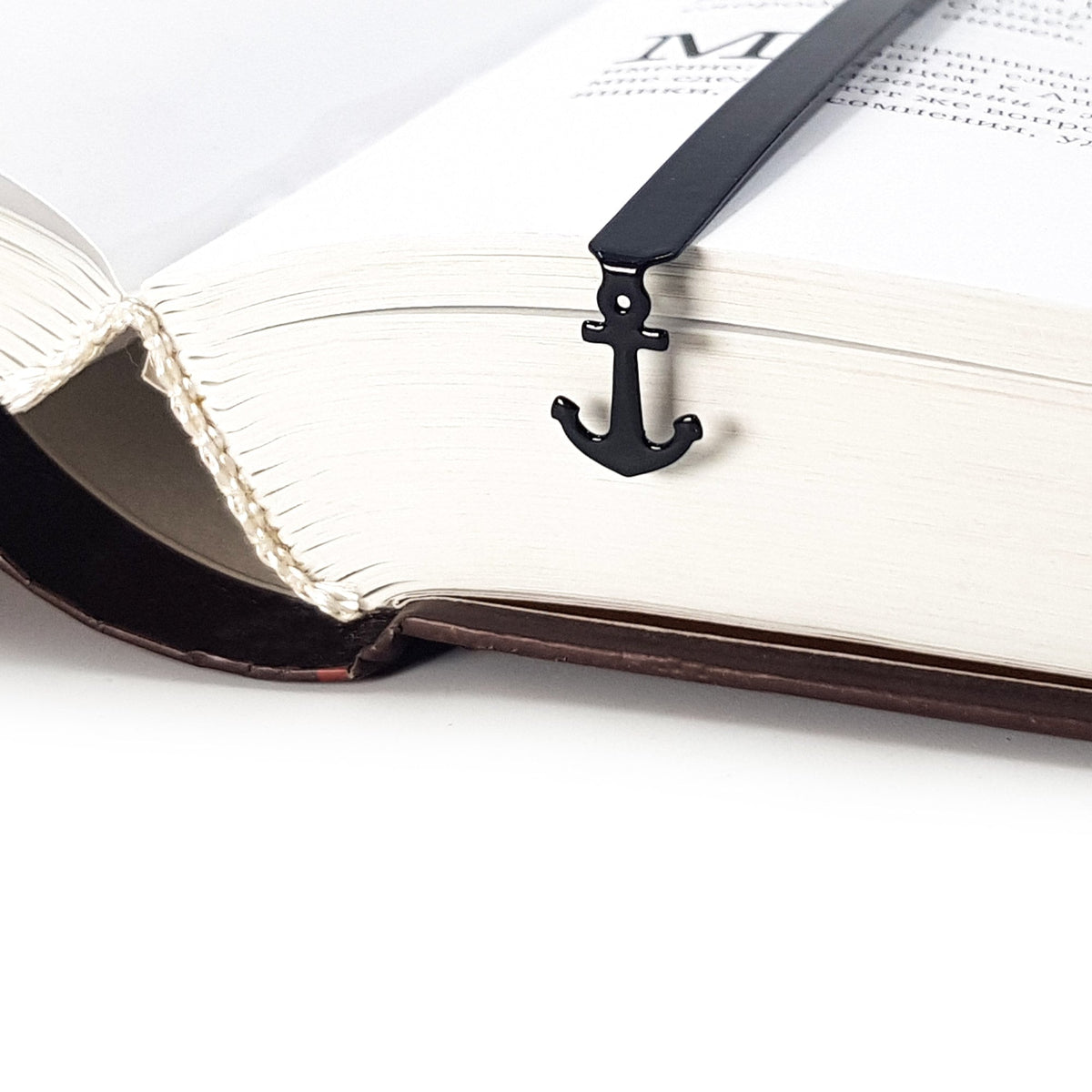 Anchor metal bookmark marking a page in a notebook