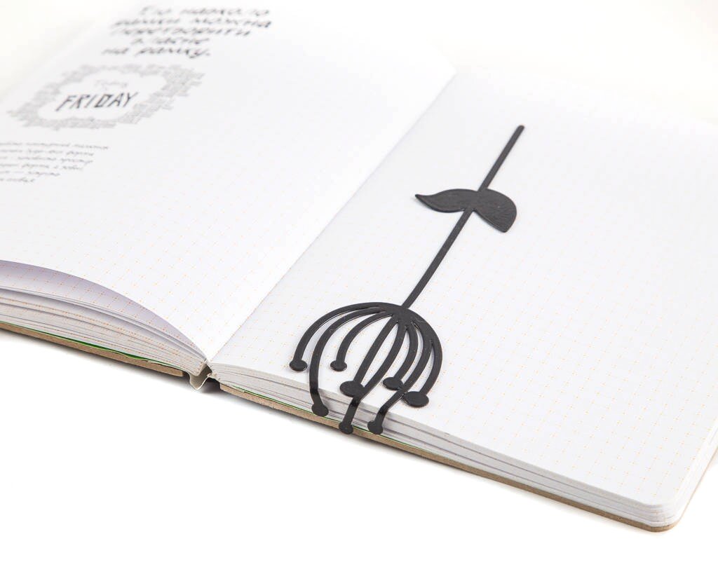 Anethum metal bookmark tucked into a notebook
