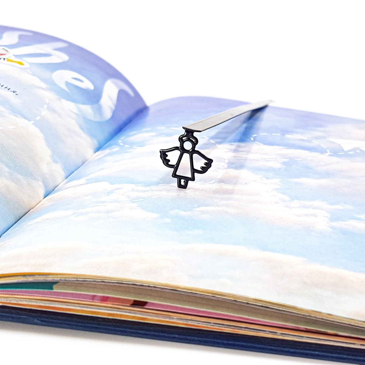 Angel metal bookmark marking a page in an illustrated book