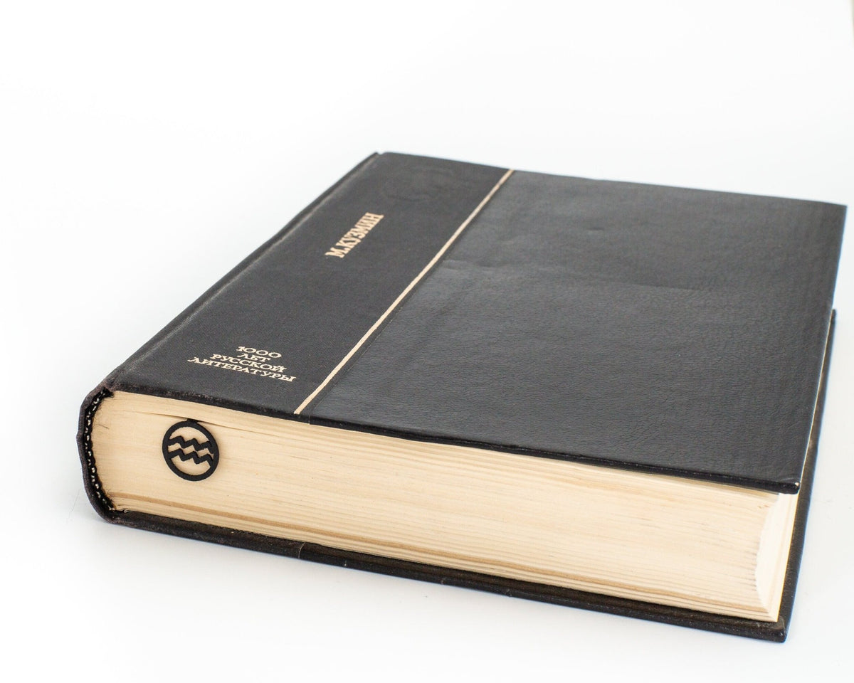 Aquarius metal bookmark seen from the edge of a closed book