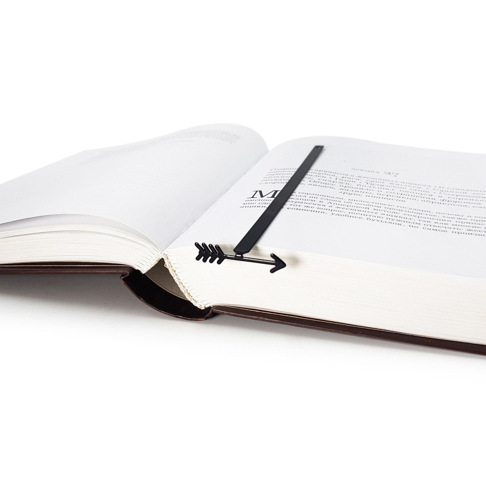 Arrow metal bookmark lying across the pages of an open book
