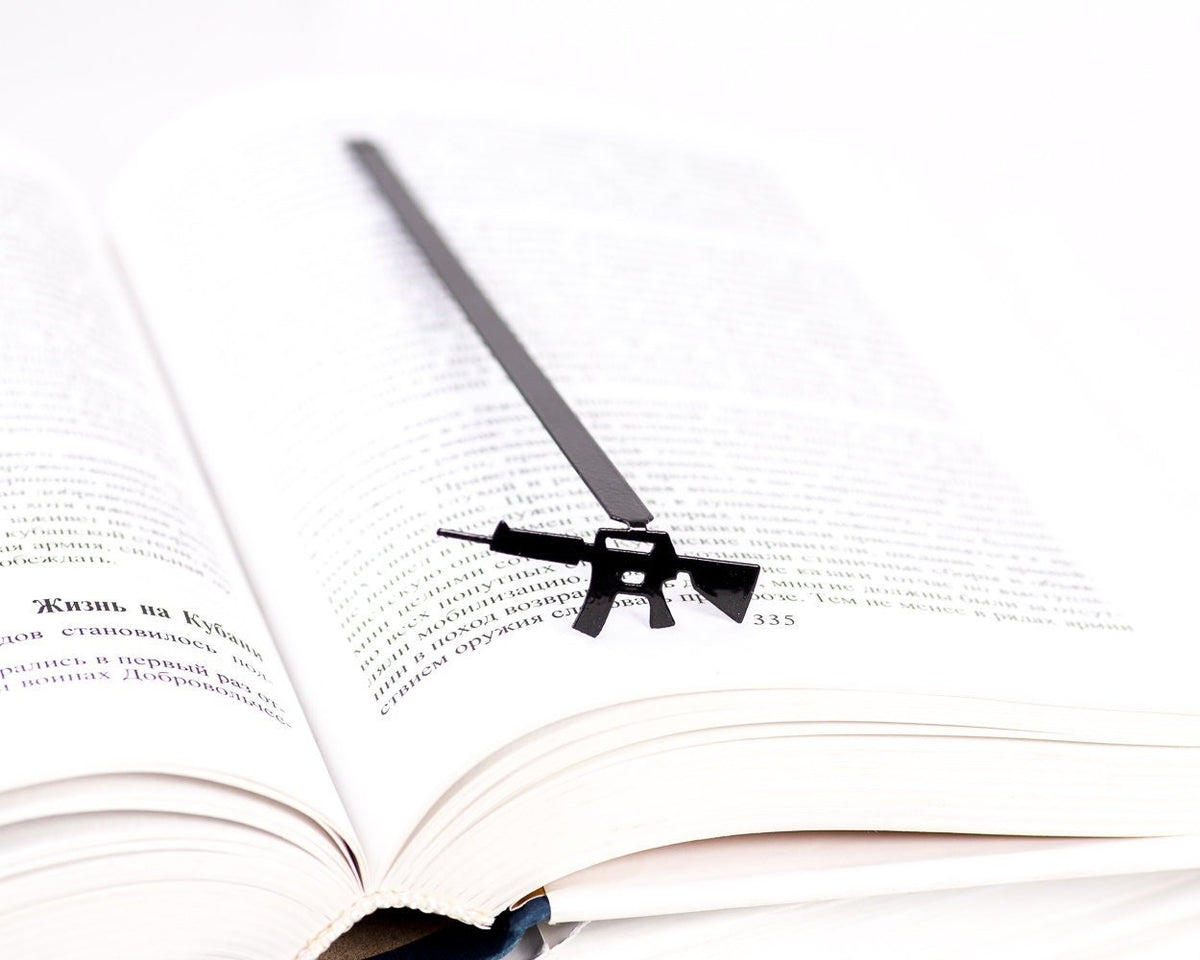 Automatic Rifle metal bookmark resting on the pages of an open book