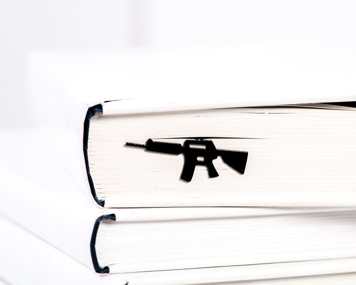 Automatic Rifle metal bookmark in a closed book, only its top showing above the pages