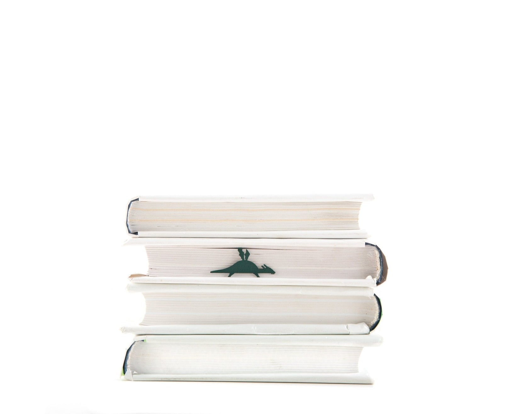 Baby Dinosaur metal bookmark shown with a stack of books