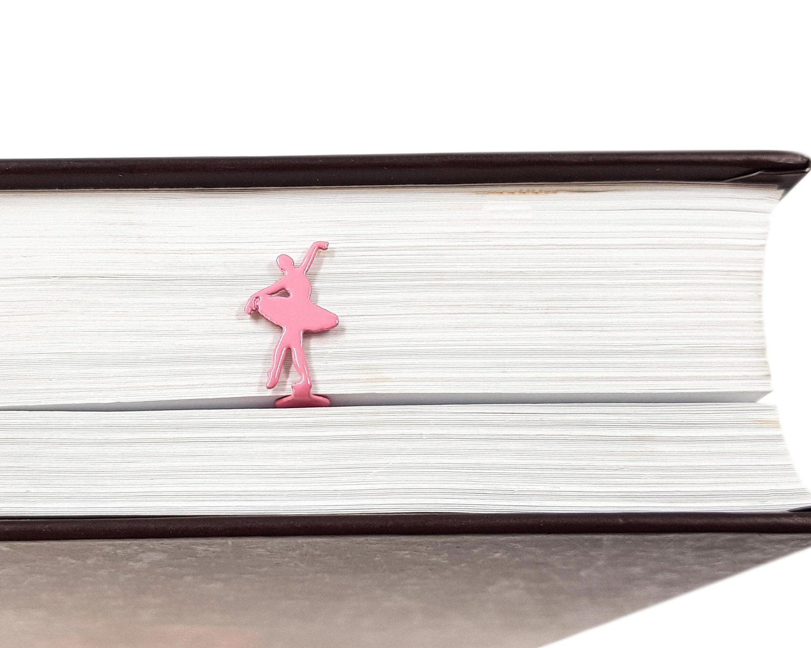Ballet Dancer metal bookmark in red resting on the pages of an open book
