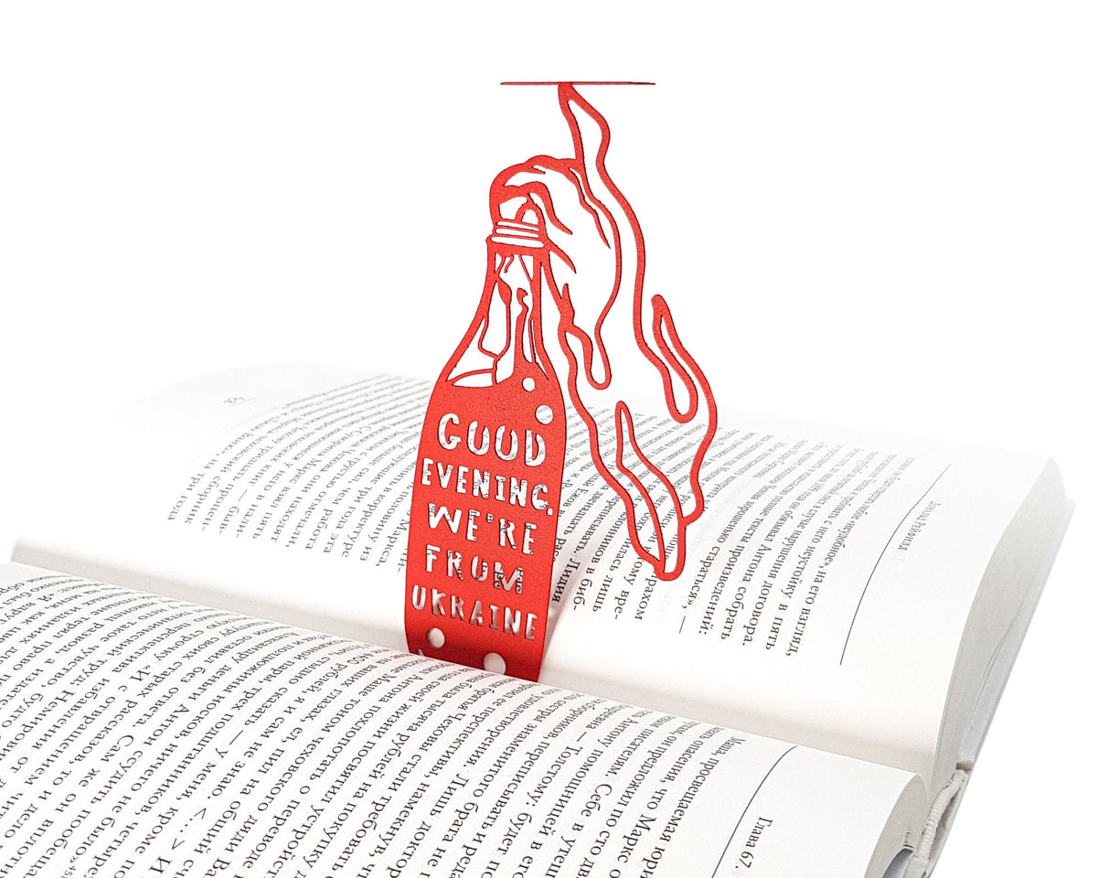 Bandera Smoothie metal bookmark in red resting on the pages of an open book