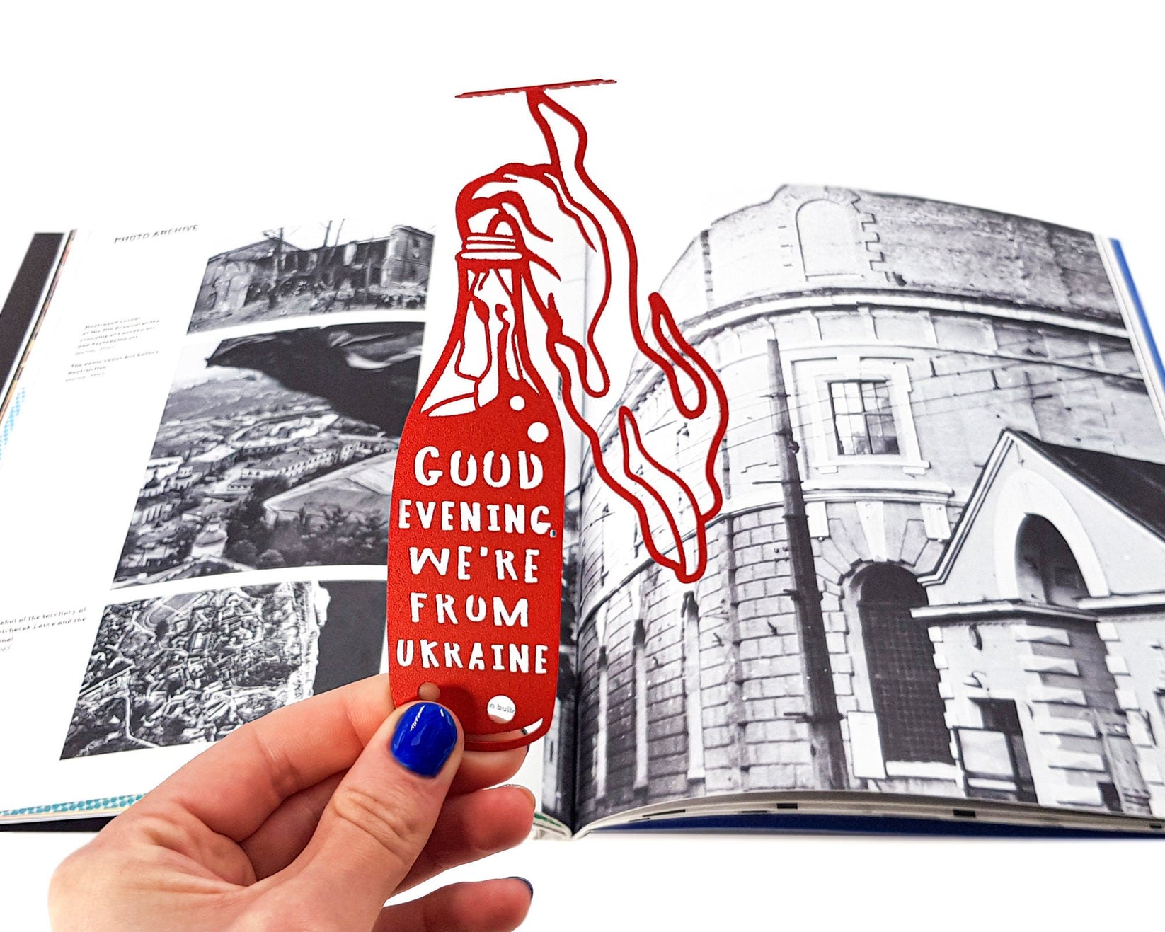 Bandera Smoothie metal bookmark in red marking a page in an illustrated book