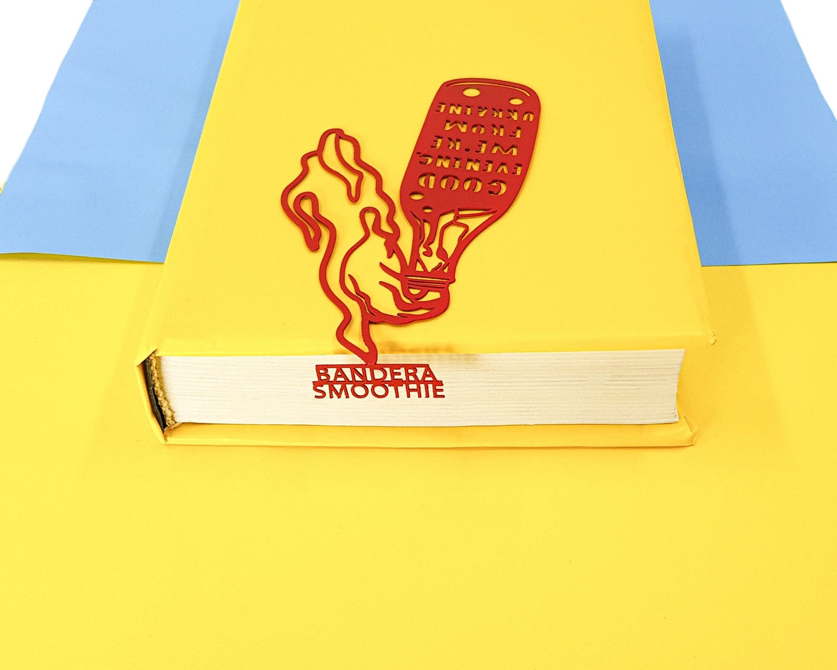 Bandera Smoothie metal bookmark in red against a coloured backdrop