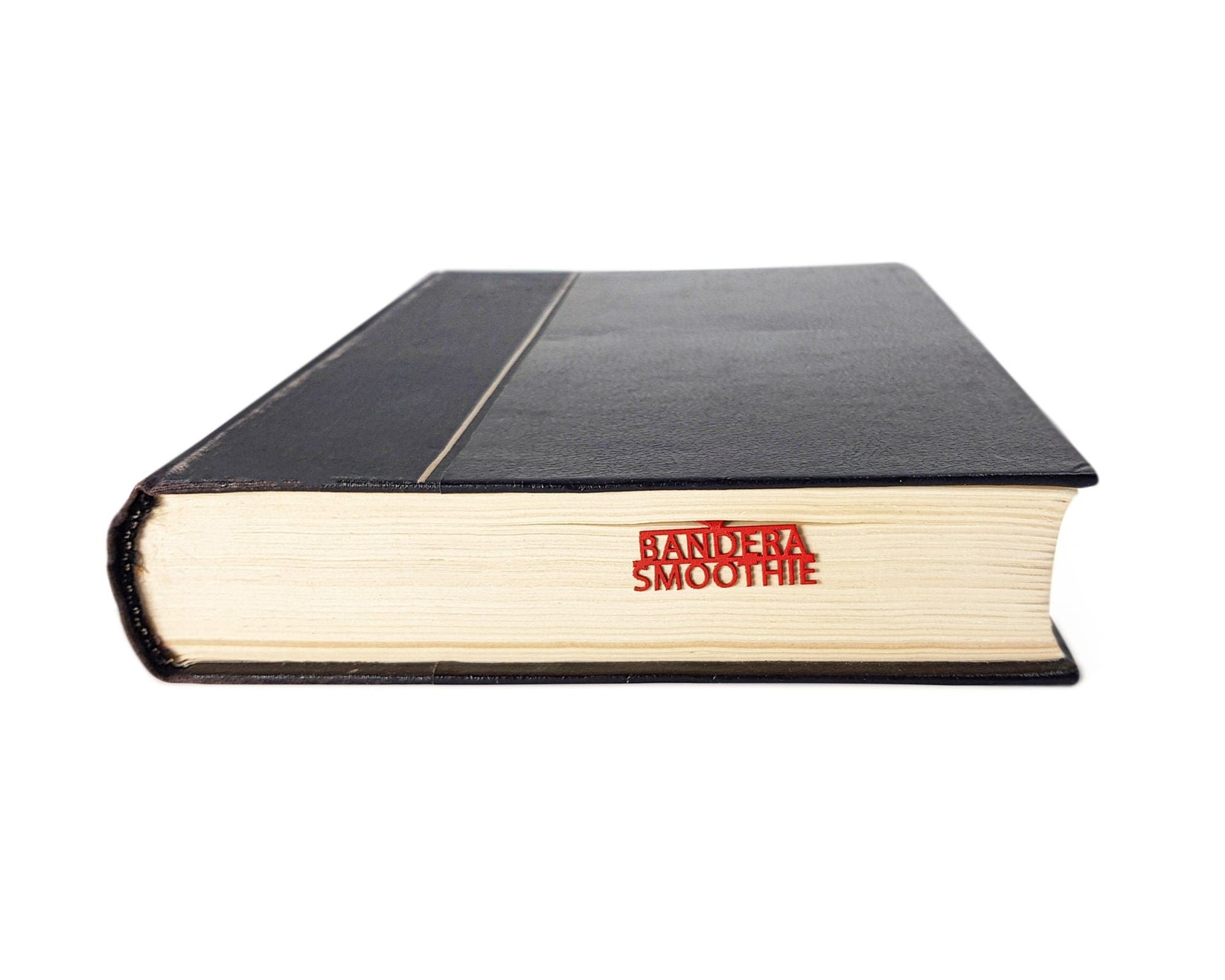 Bandera Smoothie metal bookmark in red seen from the edge of a closed book