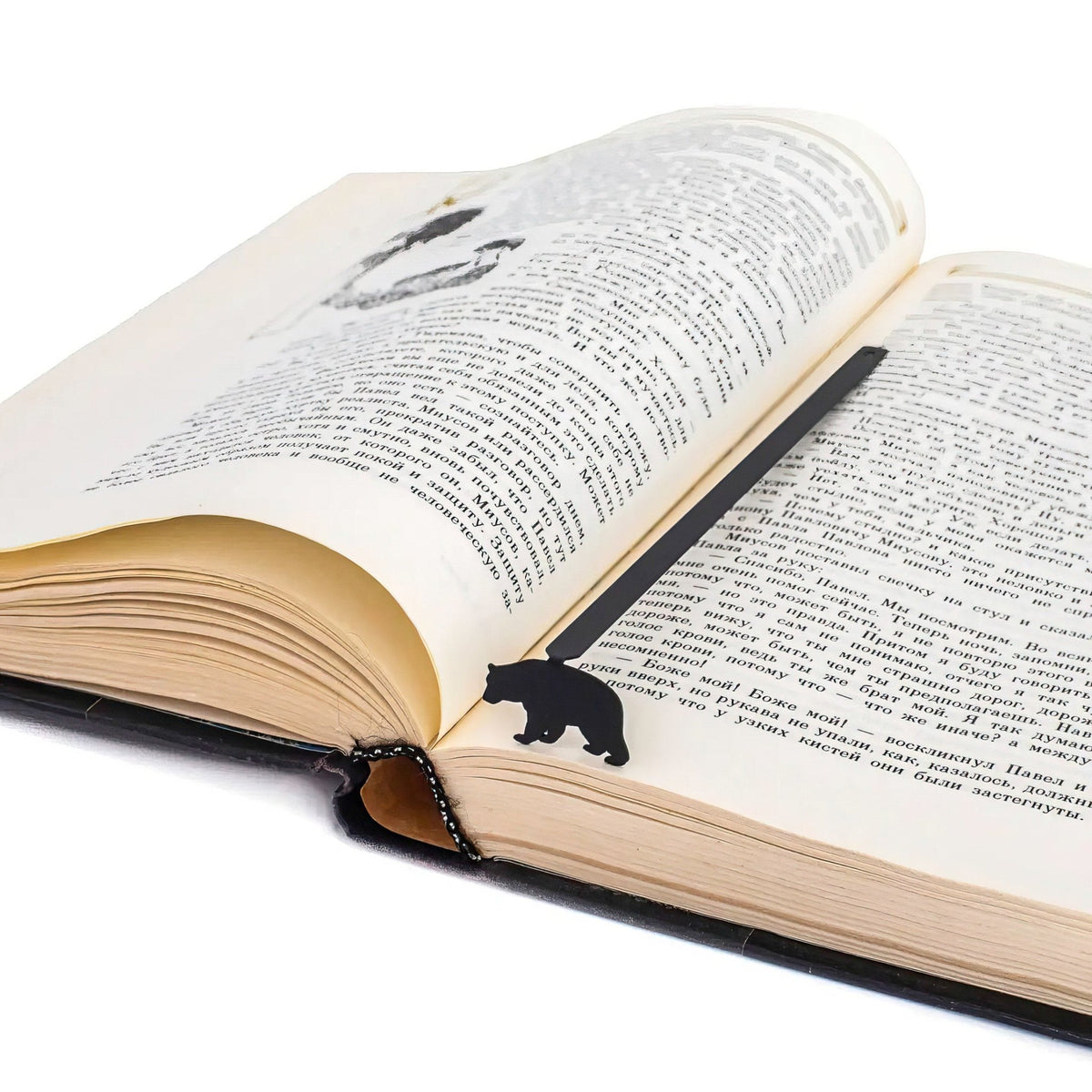 Bear metal bookmark resting on the pages of an open book